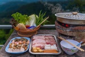 een tafel met vlees en groenten en een grill bij ภูชมดาว ม่อนแจ่ม in Mon Jam