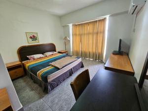 - une chambre avec un lit, une table et un bureau dans l'établissement Senorita Sea View At Ocean View Resort, à Port Dickson