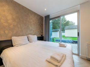 - une chambre avec un grand lit et des serviettes dans l'établissement Cozy holiday home in South Holland in a wonderful environment, à Zevenhuizen