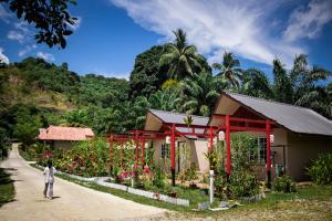 a person standing in front of a building with flowers at Timba Garden FREE TOWN AND JETTY TRANSPORT in Semporna