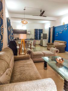 sala de estar con sofás, mesa y cocina en Melba Homestay at Kodaigate, en Kodaikanal