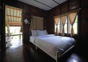 a bedroom with a bed and two windows at ภูทรายแก้วรีสอร์ทวังน้ำเขียว in Wang Nam Khieo