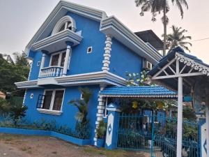 una casa azul con una puerta en Goa Garden Resort - Sandray Apartments & Villa at Benaulim - Colva beach, en Colva