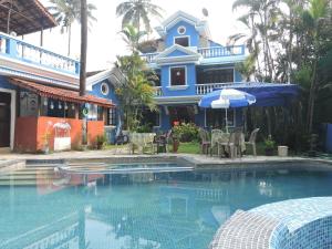 a house with a swimming pool in front of a house at Goa Garden Resort - Sandray Apartments & Villa at Benaulim - Colva beach in Colva
