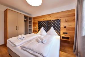 a bedroom with a large white bed with two pillows at Berghupferl in Garmisch-Partenkirchen