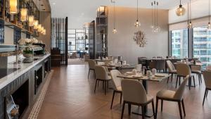 een restaurant met tafels en stoelen en een bar bij Primestay - Jumeirah Living Marina Gate 1BR Prime Location with Waterfront Views Direct access to Marina Walk in Dubai