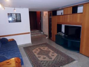 uma sala de estar com um sofá azul e uma televisão em Welcoming apartment in Valbrona with pool em Valbrona