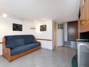 ein blaues Sofa im Wohnzimmer mit einem TV in der Unterkunft Welcoming apartment in Valbrona with pool in Valbrona