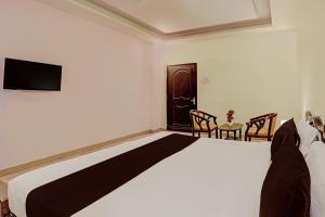 - une chambre avec un lit, une table et des chaises dans l'établissement OYO Ritesh Grand, à Hyderabad