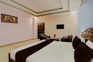 une chambre d'hôtel avec un lit et deux chaises dans l'établissement OYO Ritesh Grand, à Hyderabad