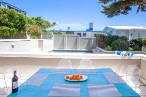 a table with a plate of oranges and a bottle of wine at Harmony Haven in Cape Town