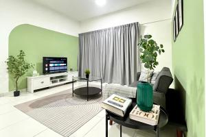 een woonkamer met een bank en een tv bij Axis Crown Residence Near KLCC in Kuala Lumpur