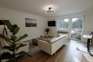 uma sala de estar com um sofá e uma mesa em Stilvolles Appartement mit Blick auf das Dreiflüsse-Eck em Passau
