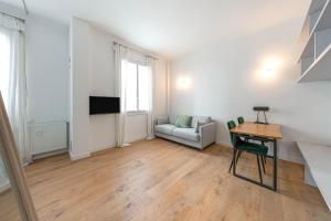 ein Wohnzimmer mit einem Tisch und einem Sofa in der Unterkunft Appartement Architecte Catalans- Bord de mer in Marseille