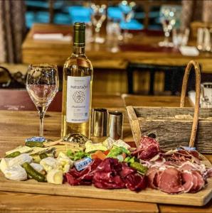 a bottle of wine and a plate of meat and vegetables at Residence bois d'aurouze pied des pistes in Le Dévoluy