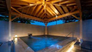 a large swimming pool with a wooden roof at EN RESORT Grandeco Hotel in Kitashiobara