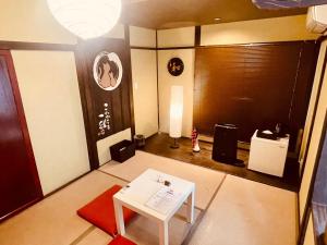 a living room with a table in the middle of a room at SAMURISE KURA in Fujikawaguchiko