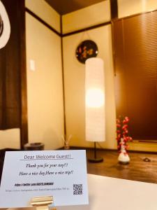 a sign sitting on top of a table with a lamp at SAMURISE KURA in Fujikawaguchiko