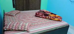 a bed with a colorful comforter and pillows on it at Hotel aasra guest house in Bharwain