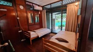 a small room with two beds and a window at Sea View Kampong Style Homestay Pengkalan Balak in Pengkalan Balak