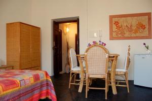 a room with a table and chairs and a bed at Casa Vacanze Magnolia in Punta Secca