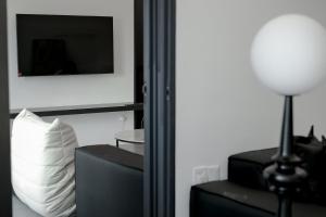 a room with a lamp and a pillow and a television at Langkawi Homestay at Simfoni Beliza Apartment by Chien in Kuah