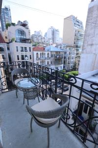 2 tafels en stoelen op een balkon met uitzicht op de stad bij THE GEM BOUTIQUE HOTEL in Beiroet