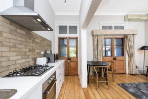 a kitchen with white counters and a stove top oven at Apartment Faro in Fremantle