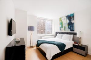 a white bedroom with a bed and a window at Lovely 2 Bedroom Apartment in New York