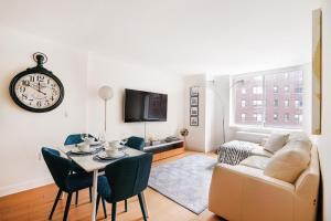 a living room with a couch and a table and a clock at Lovely 2 Bedroom Apartment in New York