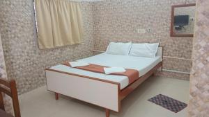 una camera con un grande letto e uno specchio di CATCH A WAVE BUDGET STAY a Mamallapuram