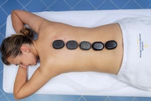 Eine Frau liegt in einer Badewanne, auf deren Rücken vier Steine liegen. in der Unterkunft Zespół Dolina Białego - Pensjonat Telimena in Zakopane + 129 Fotos