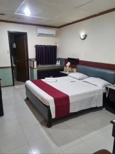 a bedroom with a large bed with a red blanket at Tiger Hotel in Angeles