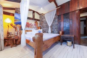 1 dormitorio con cama de madera y pared de ladrillo en Zhoujia Hostel en Zhangjiajie
