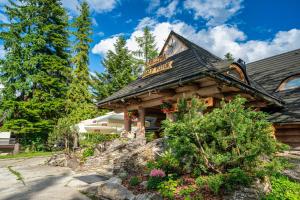 a log cabin with a sign on the roof at Zespół Dolina Białego - Pensjonat Telimena in Zakopane
