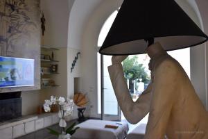 eine Person, die eine Lampe im Wohnzimmer aufhält in der Unterkunft Percebes Exclusive B&B in Cutrofiano