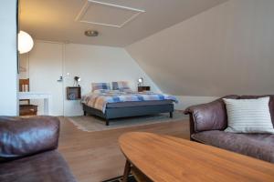 a bedroom with a bed and a couch and a table at Cosy One Villa in Struer