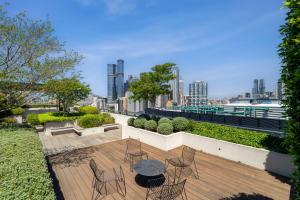 um pátio com uma mesa e cadeiras e um horizonte da cidade em The Eminence Apartments by CLLIX em Melbourne