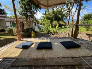 two meditation mats on a wooden deck with an umbrella at Sun Moon Pai Bungalow in Pai