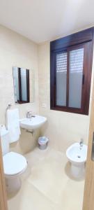 ein weißes Badezimmer mit 2 Waschbecken und einem WC in der Unterkunft HOTEL NUEVO ESPARTINAS in Espartinas