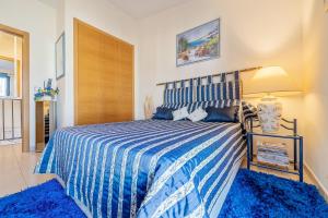 a bedroom with a blue and white bed with a lamp at Lujoso Chalet Golf Panoramica in San Jorge +28 photos