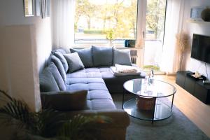 a living room with a couch and a table at Stadtwohnung mit Stadtpark Blick in Emden