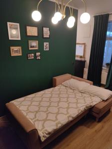 a bed in a bedroom with a green wall at Zagreb 1911 in Zagreb