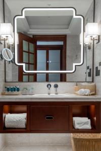 uma casa de banho com um lavatório e um espelho grande em Yancheng Shuicheng Hotel em Yancheng