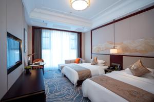 um quarto de hotel com duas camas e uma grande janela em Yancheng Shuicheng Hotel em Yancheng