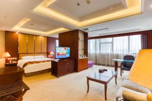 Metropark Changchun Guosheng Hotel في تشانغتشون: غرفه فندقيه سرير وتلفزيون