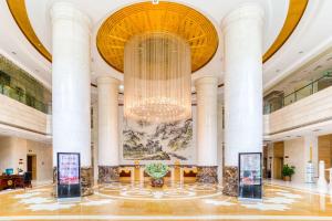 eine große Lobby mit einem großen Kronleuchter in der Unterkunft Metropark Changchun Guosheng Hotel in Changchun