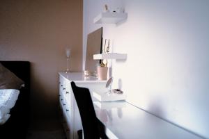a bathroom with a white sink and a mirror at Stadtwohnung mit Stadtpark Blick in Emden