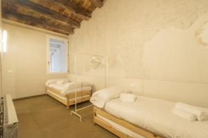 1 dormitorio con 2 camas y ventana en Ca la Francesa, en Juncosa