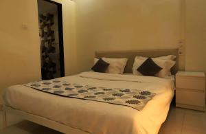 a bedroom with a large bed with white sheets and pillows at The Retreat by City Homes Aashiyaanaa in Jambhulpāda +30 photos